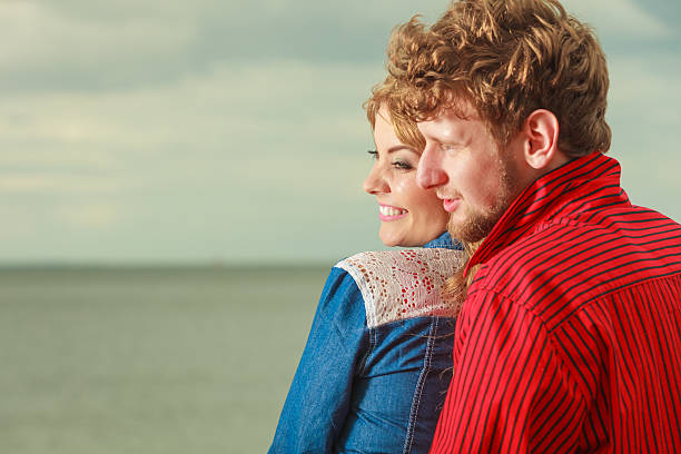 istock Couple sitting hugged on sea shore 514991810