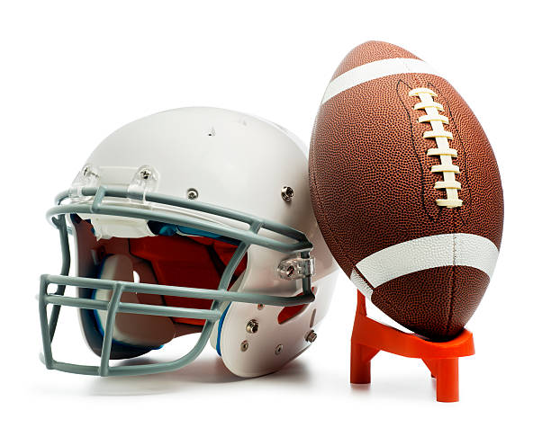 American Football This is a photo of an American football leaning against a white helmet. There is a clipping path included with this file. football helmet and ball stock pictures, royalty-free photos & images