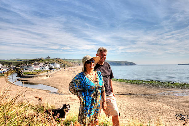 istock Mature smiling couple standing on grassy headland overlooking beach 514993707