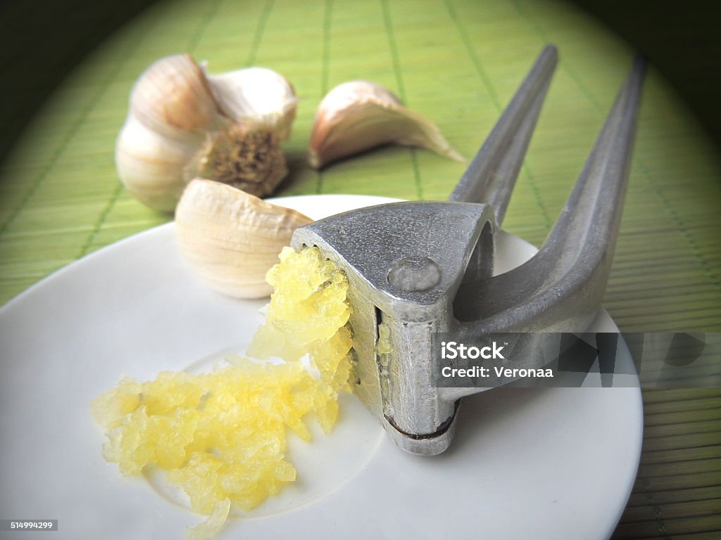 Garlic bulbs and garlic press Agriculture Stock Photo