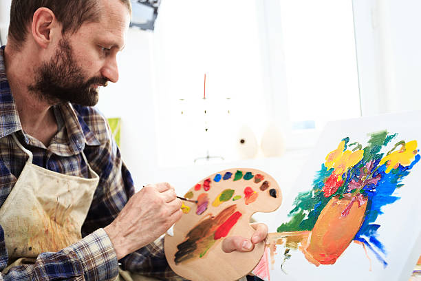 istock Male painer holding palette and drawing in his studio 514994362