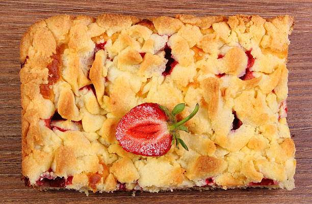 istock Fresh baked yeast cake with strawberries on wooden table 514994464