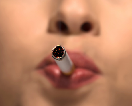 macro shot of woman portrait smoking cigarette.