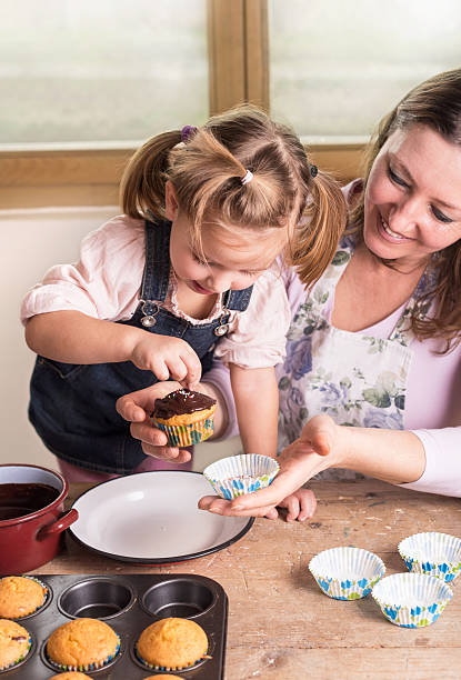 istock mother and daughter baking cupcakes 514996712