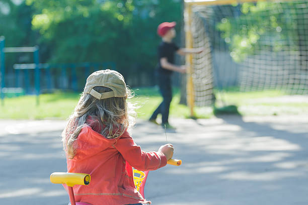 小さな女の子を見ている子供サッカー少年に接地 - football goal post goal post american football football field ストックフォトと画像