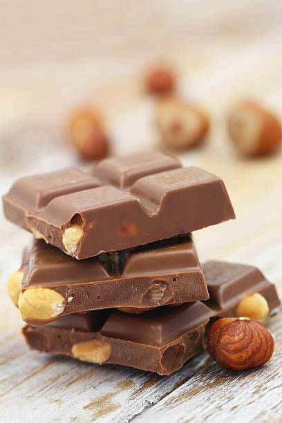 istock Milk chocolate with hazelnuts stacked on rustic wood 514999710