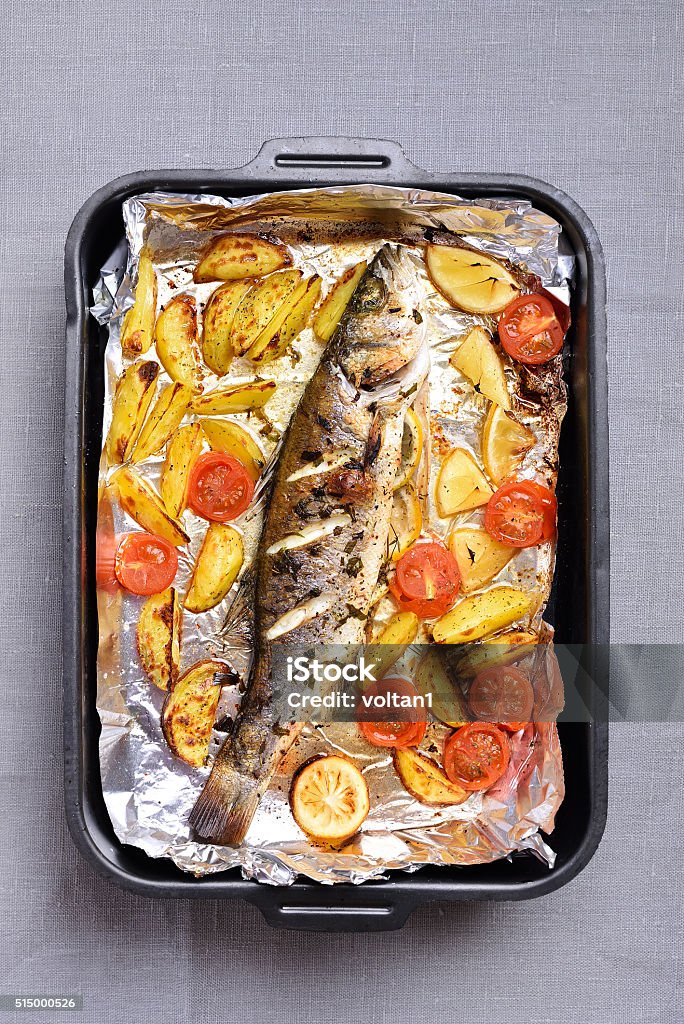 Baked vegetables and fish Baked vegetables and fish in pan, top view Foil - Material Stock Photo
