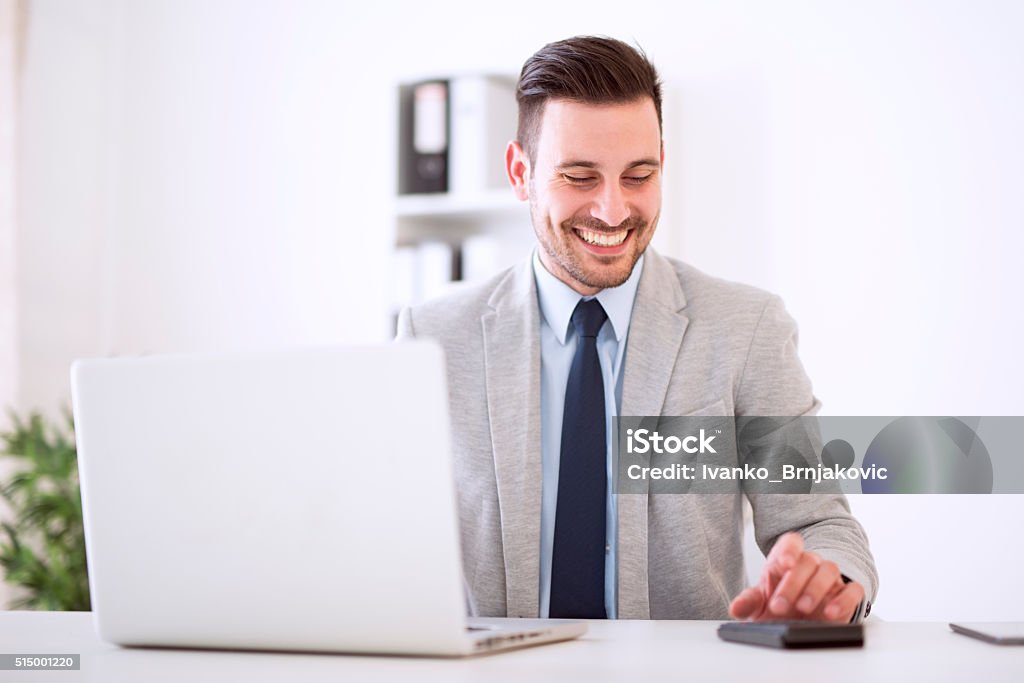 Businessman working Shot of a young businessman sitting in his office.He is working on his laptop in the office. 25-29 Years Stock Photo