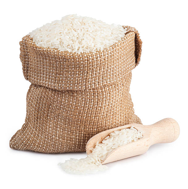 White rice in sack and wooden scoop  isolated on white stock photo