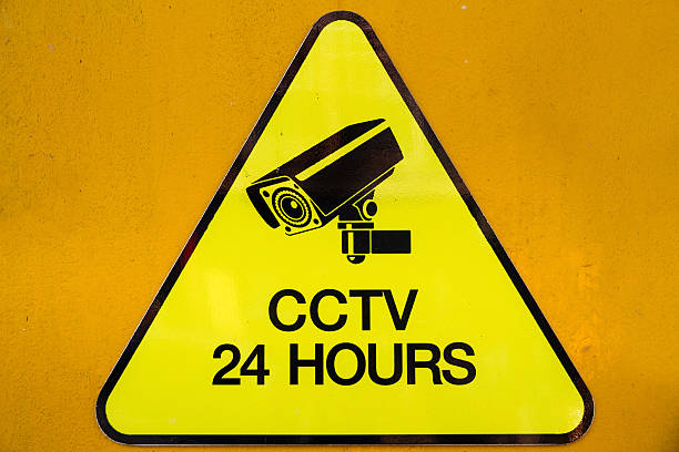 Yellow warning cctv security cameras sign stating that there is cctv cameras operating 24 hour.