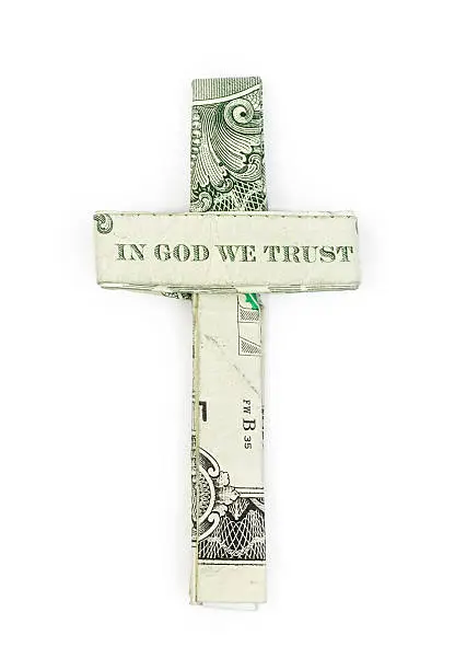 Dollar origami cross with "In God we Trust" isolated on white bacground.
