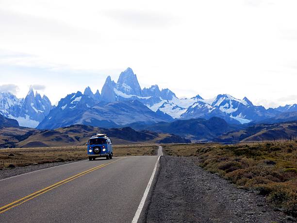 VW bus with Mount Fitz-Roy in Patagonia, Argentina El Chalten, Los Glaciares National Park, Argentina - Febuary 12, 2016:A blue VW bus driving away from the silhouette of Fitz-Roy and Cerro Torre in the Los Glaciares National Park in Argentina chalten photos stock pictures, royalty-free photos & images