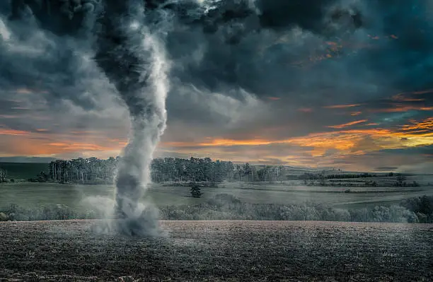 Photo of Black tornado funnel over field during thunderstorm