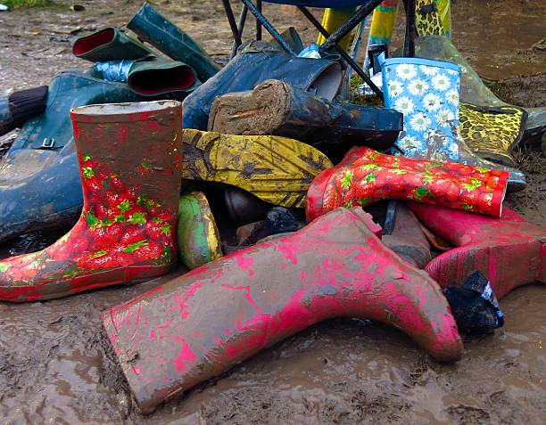 group of muddy wellies Wellington Boots discarded at music festival stock photo