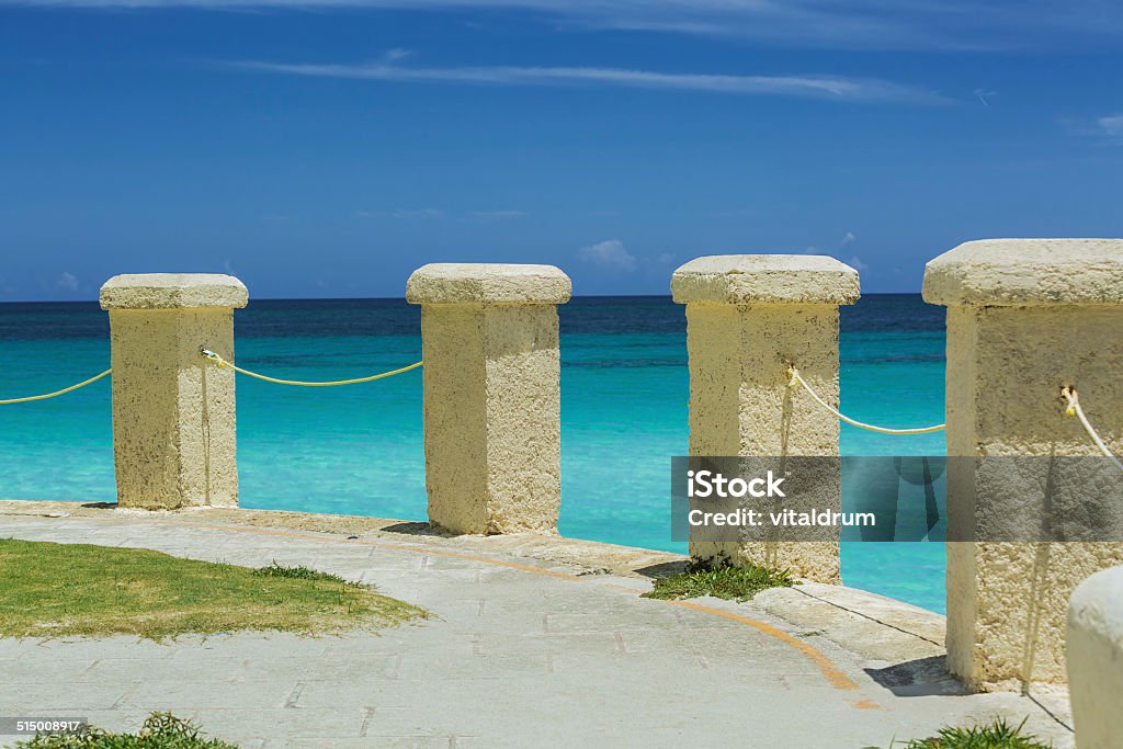colonial style stone posts on a cliff edge ocean background Amazing old colonial style stone posts on a cliff edge, above the tranquil clear ocean against dramatic blue sky Blue Stock Photo