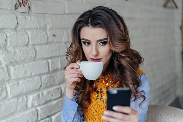 istock Beautiful girl drinking tea and working with phone 515010536
