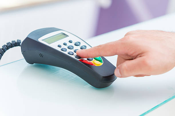 Credit card reader Man's hand using the keypad on a credit card reader enter key computer keyboard computer key white stock pictures, royalty-free photos & images