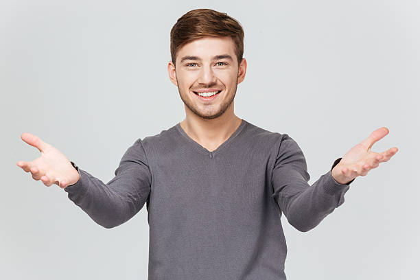 istock Cheerful handsome young man smiling and showing welcoming gesture 515011688