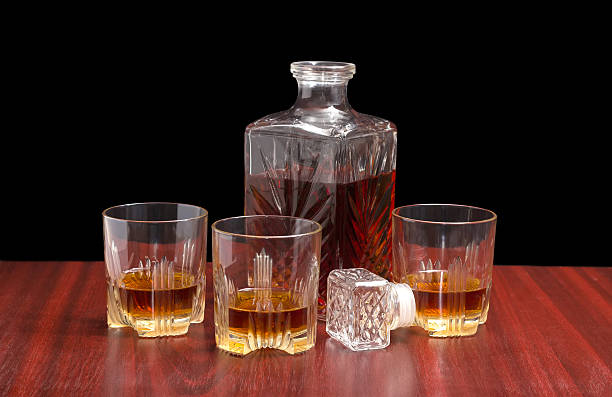 istock Decanter and three glasses with whiskey on a wooden table 515013234