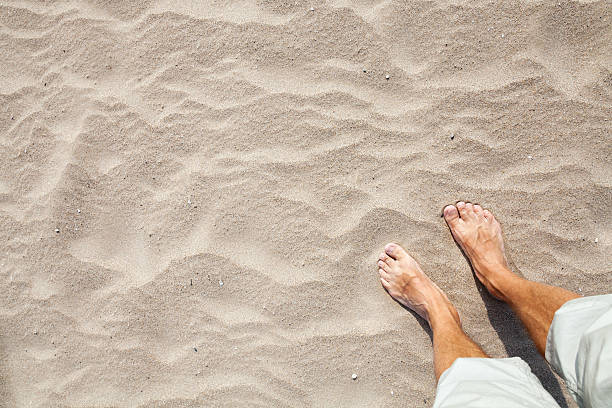 istock Legs of Young Caucasian man standing on a sandy beach 515013635
