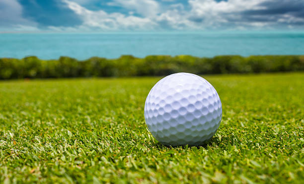 istock Golf ball on green grass with the ocean background 515014869