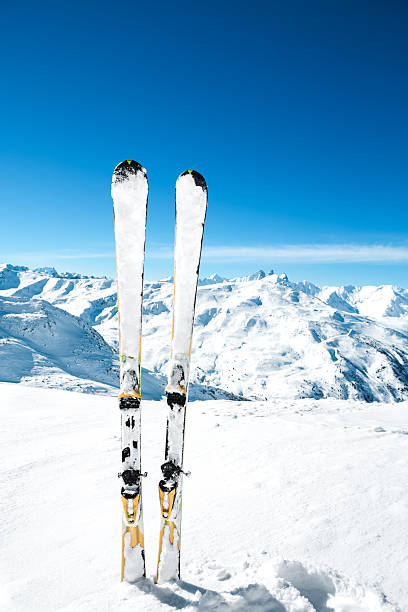 Skis In The Snow Skis covered with snow on the ski slope in Alps (France). top of ski mountain stock pictures, royalty-free photos & images