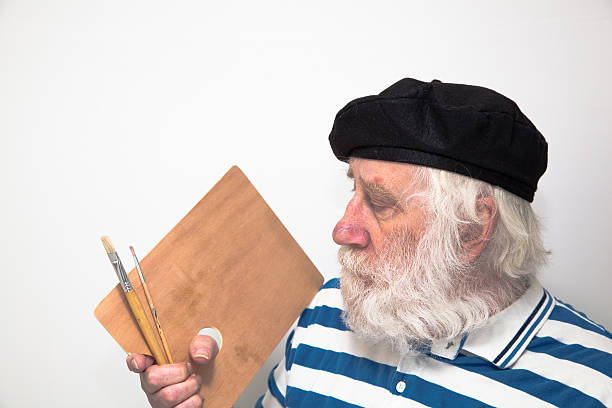 bearded artist with beret holds palette and brushes