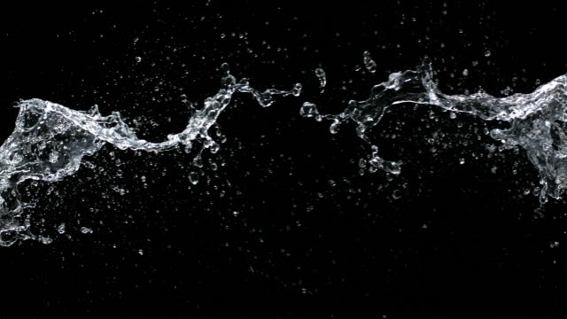 SLO MO Two water jets colliding on black background