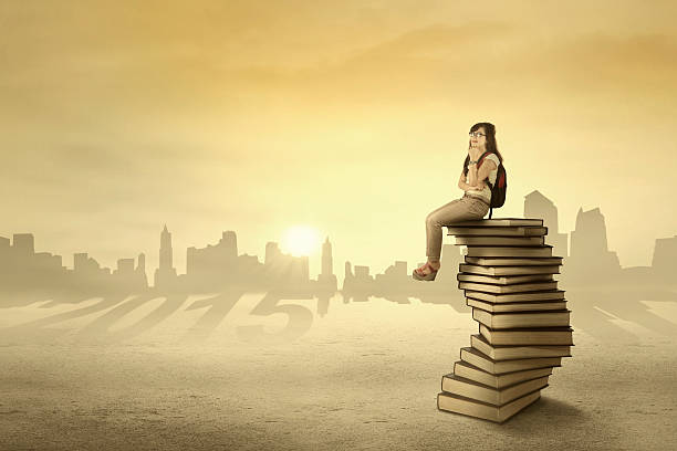 istock Student sitting and dreaming above books 515047967