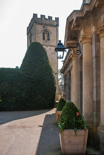 fascade de uma casa de campo e uma igreja - english culture mansion non urban scene hotel - fotografias e filmes do acervo