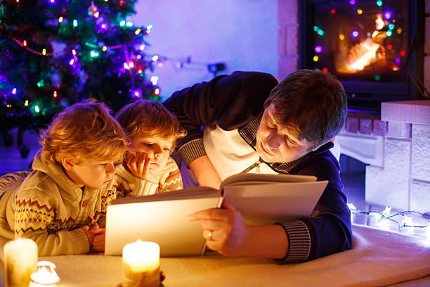 istock Young father and his little sons reading book at christmas 515053373