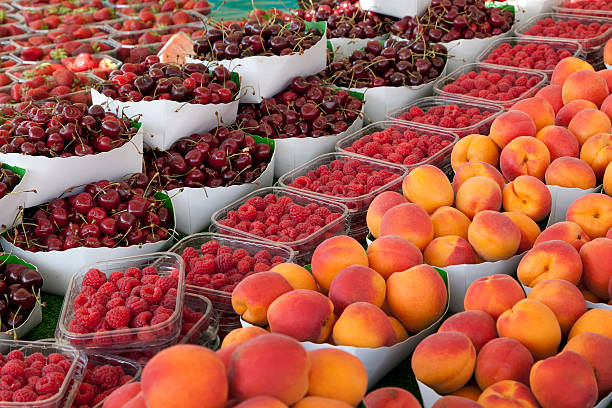 In Paris, France at the outdoor Montparnasse Market a variety of produce is for sale. Fruit and vegetables are displayed on the vendor’s table.