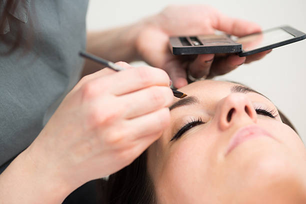 istock Beautitian Drawing Eyebrows, Pretty Brunette in Beauty Salon 515055646