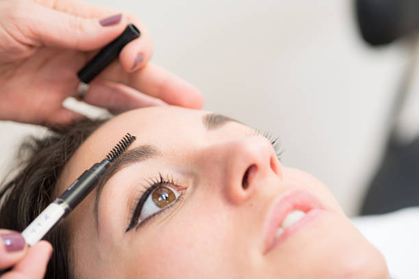 istock Beautician Brushing Eyebrows, Pretty Brunette in Beauty Salon 515055852
