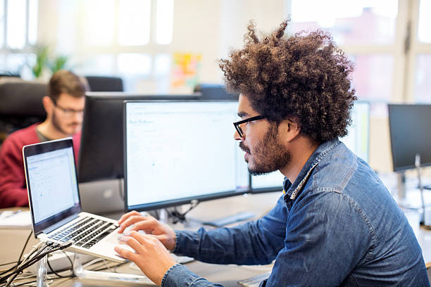 hombre con peinado afro trabajando en su escritorio - fundador fotografías e imágenes de stock