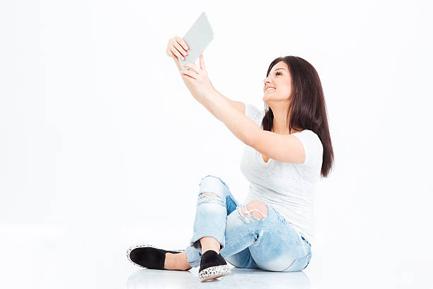 istock Smiling casual woman making selfie photo on tablet computer 515057370