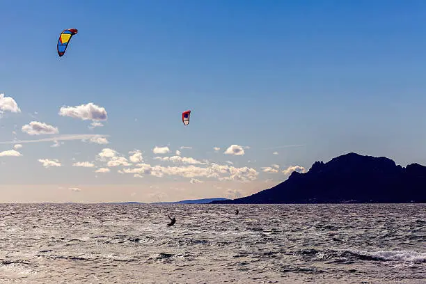 Two silhouettes of  kite surfer doing sports on the Mediterranean