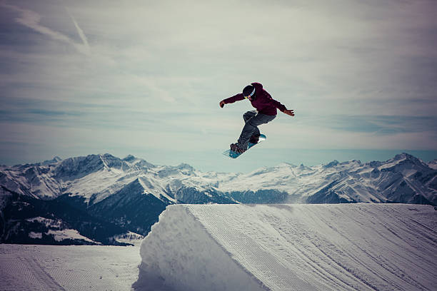 Snowboard jumps a 180 Snowboarder jumps a 180 in Laax graubunden canton stock pictures, royalty-free photos & images