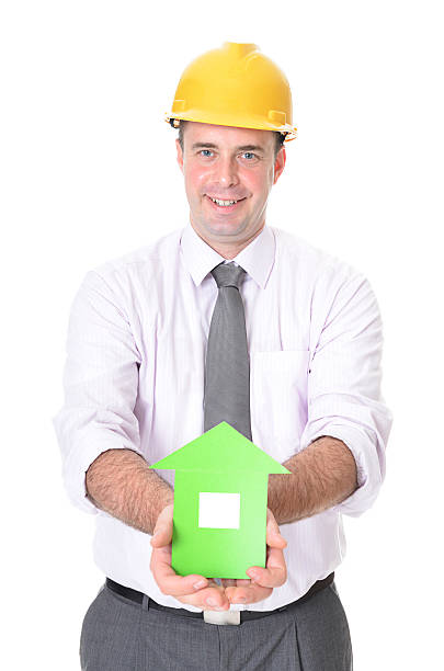 istock Smiling buinessman engineer with hardhat, suit and green house model 515061906