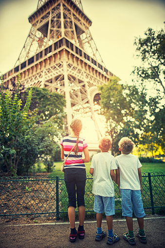 Little girl with her younger brothers are looking at the Eiffel Tower. Paris, France.
