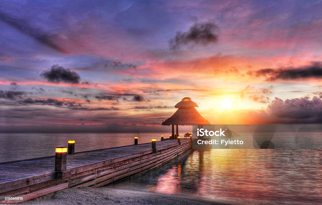 Sunset in the paradise Awsome vivid sunset over the jetty in the Indian ocean, Maldives. HDR Beauty Stock Photo