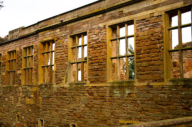 Rufford Abbey Stone Wall With Window Details Rufford Abbey is a medieval monastery founded in 1147. Now open to the public and set in 150 acres of beautiful grounds, Rufford is a key tourist attraction in Nottinghamshire. It was once the home of aristocracy, but no-one now lives there. This gargoyl is only one of the many architectural details on the Cistercian ruin. This wall has remained more intact than others, and gi9ves us an appreciation of how good these Monks were at building! gargoyl stock pictures, royalty-free photos & images