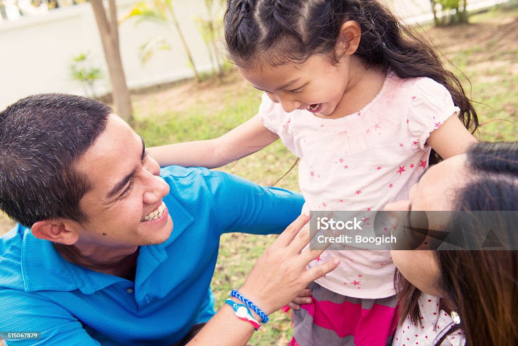 Young Thai Family Spending Time in Front of Home Young family of Thai and American descent spends time in the front yard of their home in Nakhon Ratchasima, Thailand. 20-29 Years Stock Photo