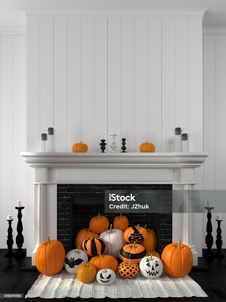 White fireplace decorated with pumpkins for Halloween Beautiful white fireplace in the classic style against a white wall and decorated with painted pumpkins Halloween Stock Photo