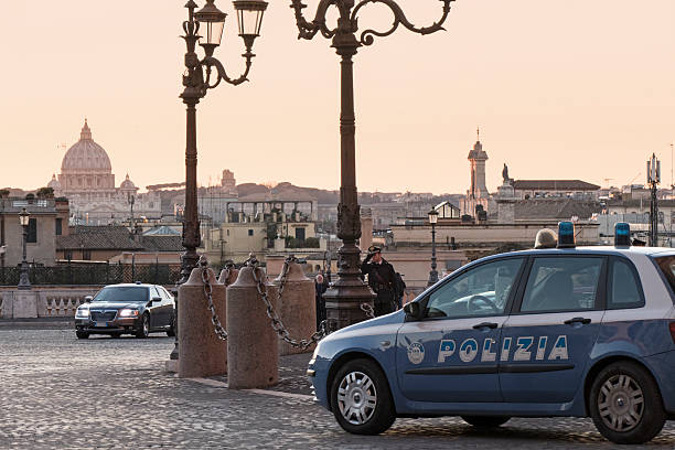 Italian Police Rome, Italy - February 20, 2016: foreground, Italian police car on the square of the Quirinale Palace - it is the  official residence of the President of the Italian Republic - and St. Peter's dome on the background. Policeman is guarding the area. The surveillance has been strengthened after terroristic threats. quirinal palace stock pictures, royalty-free photos & images
