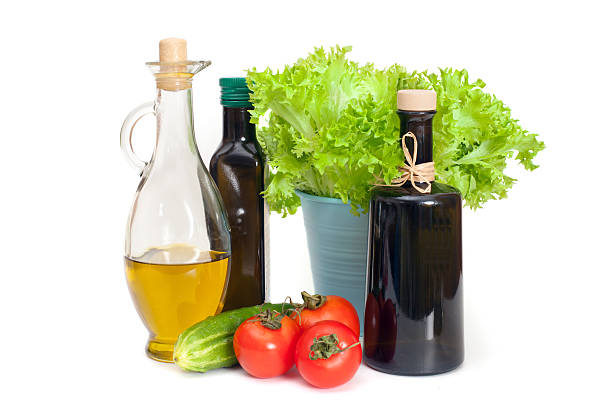 olive's-öl in flaschen mit salat oder gemüse - vinegar bottle herb white stock-fotos und bilder