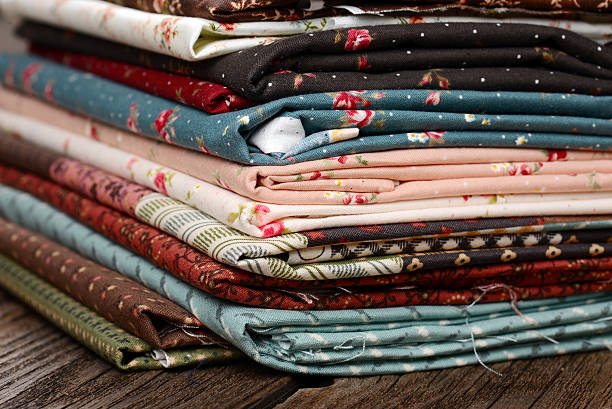 istock heap of cloth fabrics on wooden table 515071557
