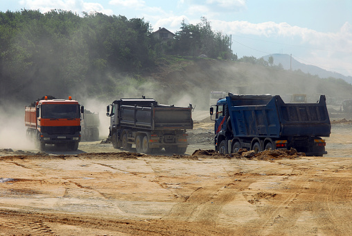 large trucks transporting stones on a construction site