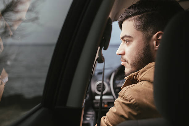 istock Handsome man sitting in his car and looking at window 515075136