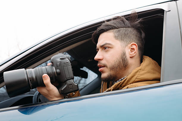 istock Handsome man with camera photosthooting from car 515075604